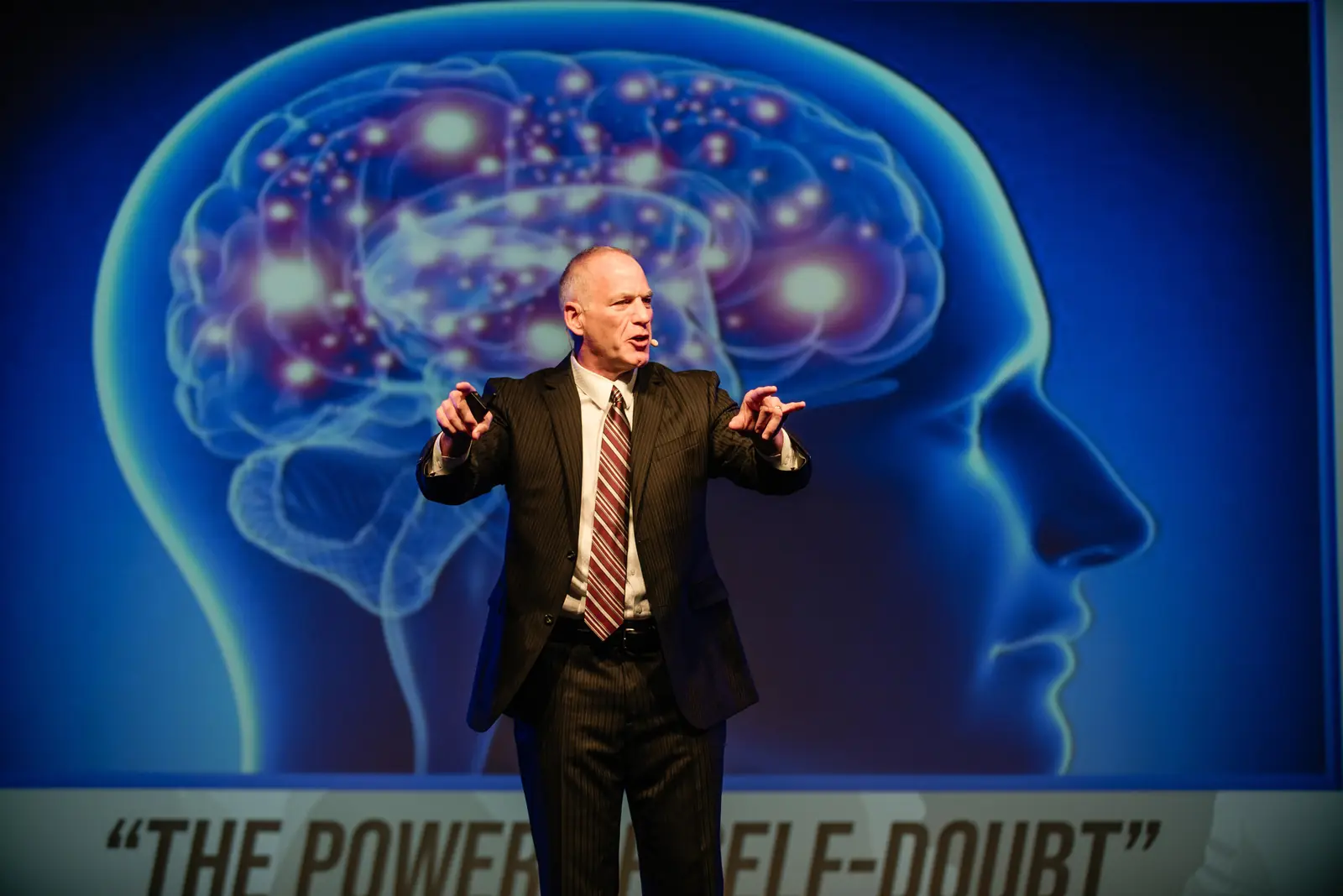 Keynote speaker on stage in front of a large projection