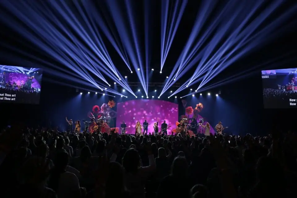 Worship concert with beam lighting and side video screens
